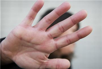 Eine Frau streckt abwehrend ihren Arm aus.