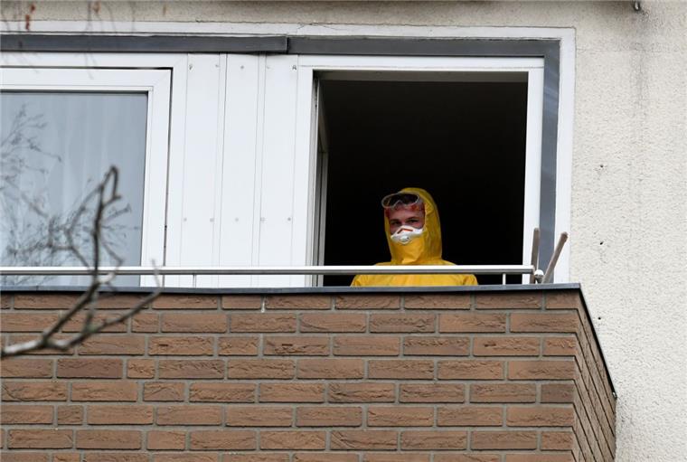 Gefährliches Virus: Ebola-Verdacht in Niedersachsen nicht bestätigt In Schutzkleidung steht ein Mitarbeiter der Feuerwehr auf dem Balkon einer Wohnung in einem Mehrfamilienhaus in Hannover. Eine Bewohnerin hatte wegen hohen Fiebers einen Notarzt gerufen.