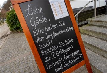 Ein Schild vor der Eingangstür weist auf die 2G Plus Regel in der Gaststätte hin.