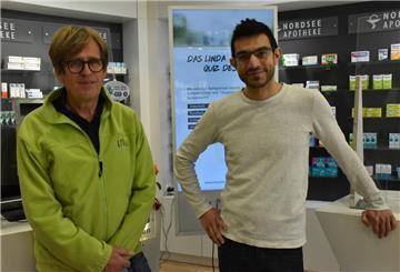 zwei Männer vor einer Auslage in Apotheke