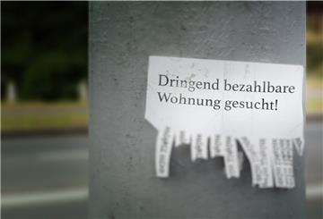 Ein Zettel mit einem Wohnungsgesuch hängt an einem Betonpfeiler