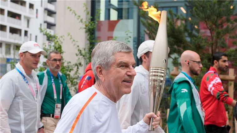 IOC-Chef Thomas Bach trug die Fackel am Freitagvormittag ein Stück weit durch das olympische Dorf.