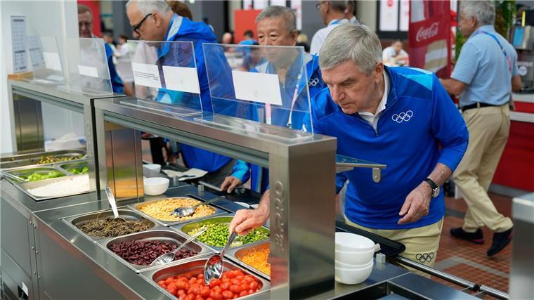 Olympia-Macher: Sportler bekommen mehr Essen IOC-Präsident Thomas Bach (r) testete auch das Essen im olympischen Dorf.