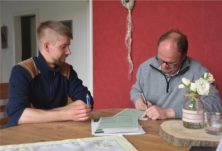 Mais fordert Biobauern heraus Das Foto zeigt den frischgebackenen Biobauern Jan Kaiser bei der Vertragsunterzeichnung. Daniel Bischoff, Erzeuger- und Umstellungsberater bei Bioland, schaut ihn dabei zu.