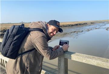 Jan-Michael Schönebeck demonstriert die Nutzung eines der insgesamt vier "Coast-Snap-Rahmen" am Langwarder Groden.