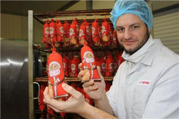 Jan-Peter Mehring zeigt die Bauernmettwurst im Weihnachtsmann-Mantel.  