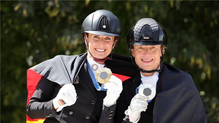 Warum Reiten so erfolgreich ist und wie Thomas Müller hilft Jessica von Bredow-Werndl (l, Gold) und Isabell Werth (Silber) zeigen nach der Siegerehrung ihre Medaillen.