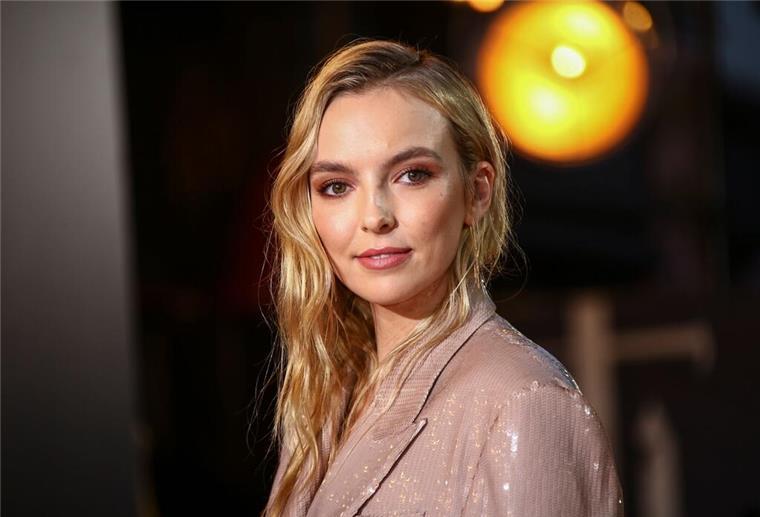 Jodie Comer steht mit Hugh Jackman vor der Kamera.