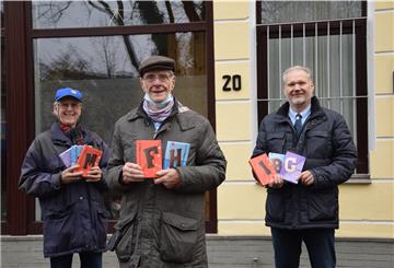 Jörn Wettermann (links) und Hajo Renno (rechts) vom Rotary-Club Nordenham überreichen Fred Memenga von der Tafel Schokolade aus den Niederlanden.