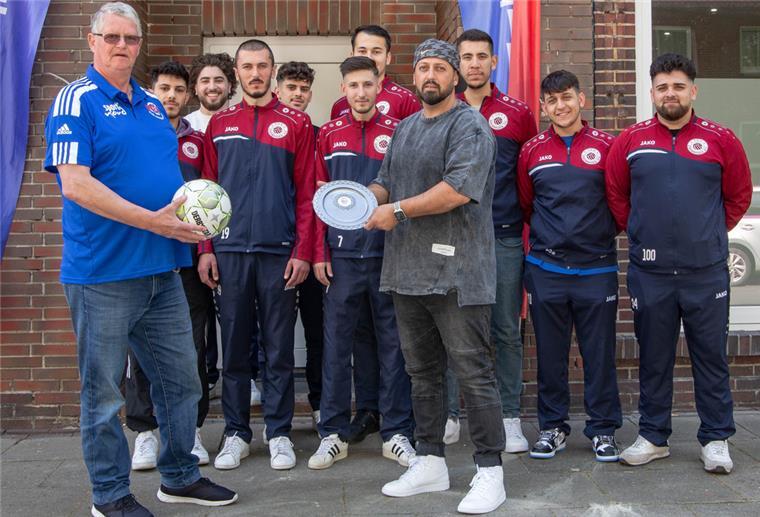 Johann Meyeraan (links) aus dem Vorstand des Fußballkreises ehrte die Mannschaft von Trainer Yasin Güngör für die Meisterschaft.