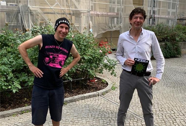 Joshi von der Punkband ZSK (links) überreicht dem Virologen Christian Drosten eine Single mit dem Drosten-Song „Ich habe Besseres zu tun“.