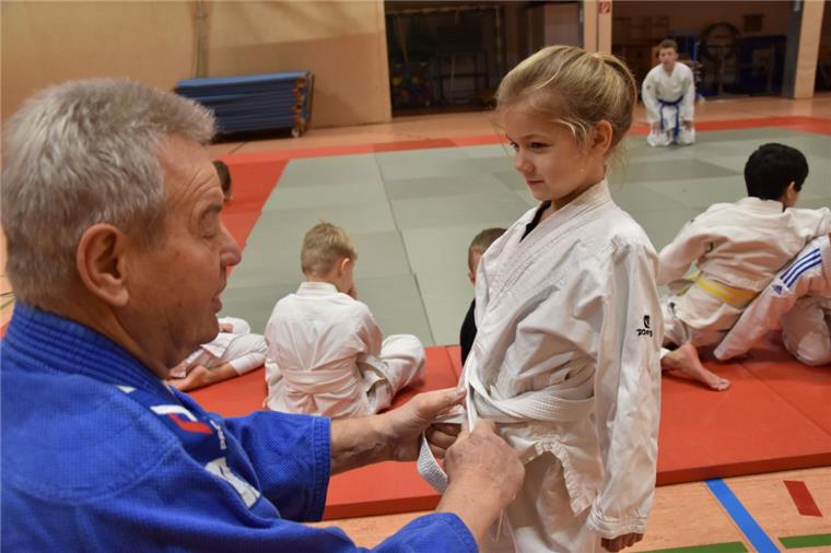 Mit 79 Jahren voll engagiert: Judoka trainiert Kinder in Beverstedt Judo-Trainer Eckhard Lehmann zurrt den Knoten von Jolins Gurt sorgfältig fest, bevor die Sportstunde losgeht. Foto: Rendelsmann