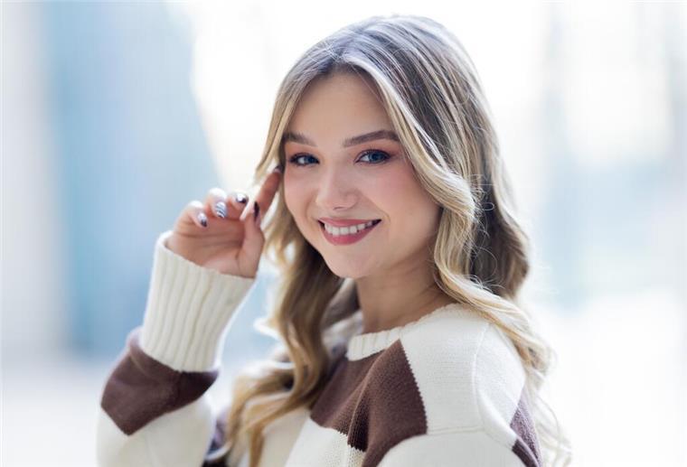 Julia Beautx möchte nicht als Youtube-Mädchen gesehen werden Eine junge Frau lächelt in die Kamera und streicht sich eine Haarsträhne aus dem Gesicht.