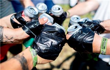 Junge Festivalbesucher stoßen auf dem Zeltplatz des Hurricane Festivals mit Dose...