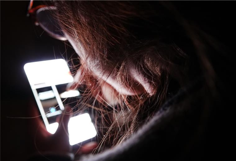 Immer mehr junge Menschen mediensüchtig Eine junge Frau bedient ihr Smartphone (gestellte Szene).