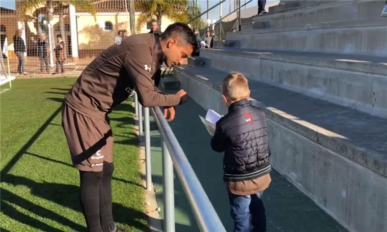 Dieser Junge aus Loxstedt-Düring (5) begeistert die St. Pauli-Profis Justus Engel aus Düring zeigt einem Spieler des Fußball-Zweitligisten FC St. Pauli sein Malbuch.