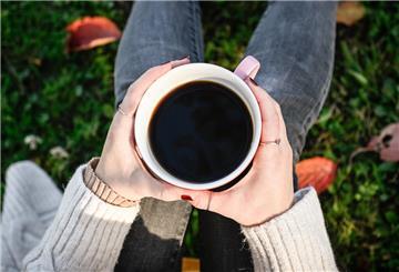 Eine Frau hält eine Tassee Kaffee