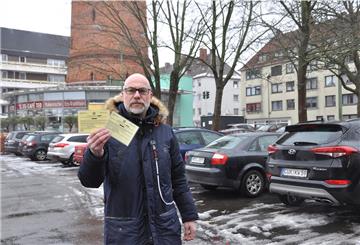Kai Martin Ulrich hält seine Anwohner-Sondergenehmigungen fürs Parken in die Höhe. 