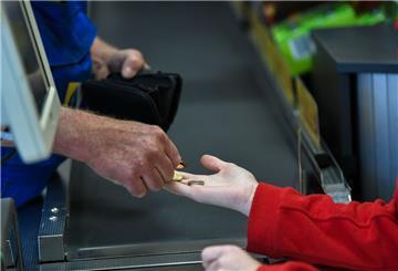 An einer Supermarktkasse wird mit Kleingeld bezahlt.