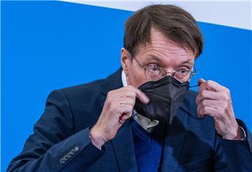 Karl Lauterbach (SPD), Bundesgesundheitsminister, setzt nach einem Treffen in der Staatskanzlei seinen Mund-Nasen-Schutz auf. 