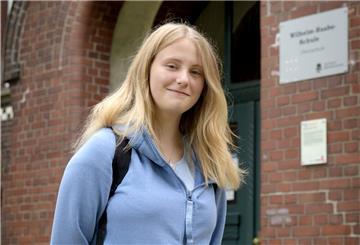 Die Schülerin Kathrin Berger steht vor dem Portal der Wilhelm-Raabe-Schule.