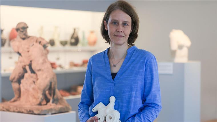 Kathrin Jaschke vom Römisch-Germanischen Museum hält die Nachbildung eines römischen Kinderspielzeugs in Händen.  