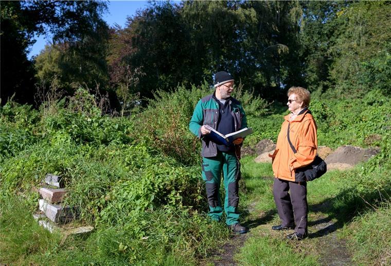 Verwildertes Gräberfeld empört Angehörige Ein Mann und eine Frau stehen auf dem Gelände eines Friedhofs.