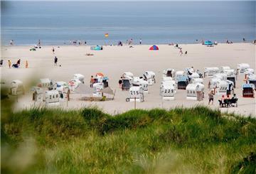 Ein Nordsee-Strand mit Strandkörben. Im Hintergrund ist das Meer zu sehen.