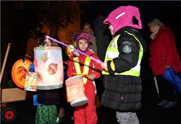 Kinder, Eltern und Mitarbeiter die Kita Regenbogen zogen mit ihren Laternen durc...