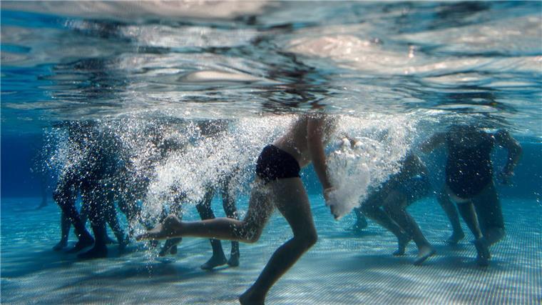 Kritik: Auslaufen des Förderprogramms für Hallenbadsanierung Kinder spielen im Becken eines Freibads.