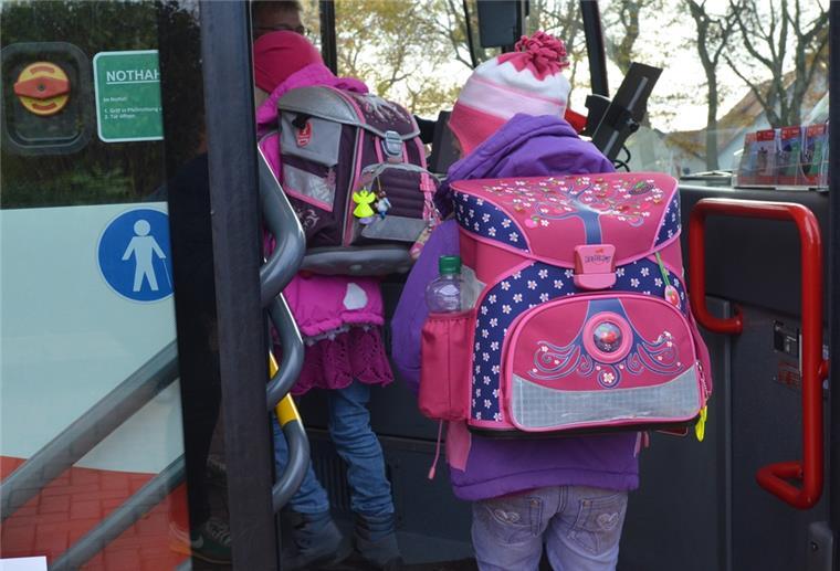 Kinder steigen in einen Schulbus.