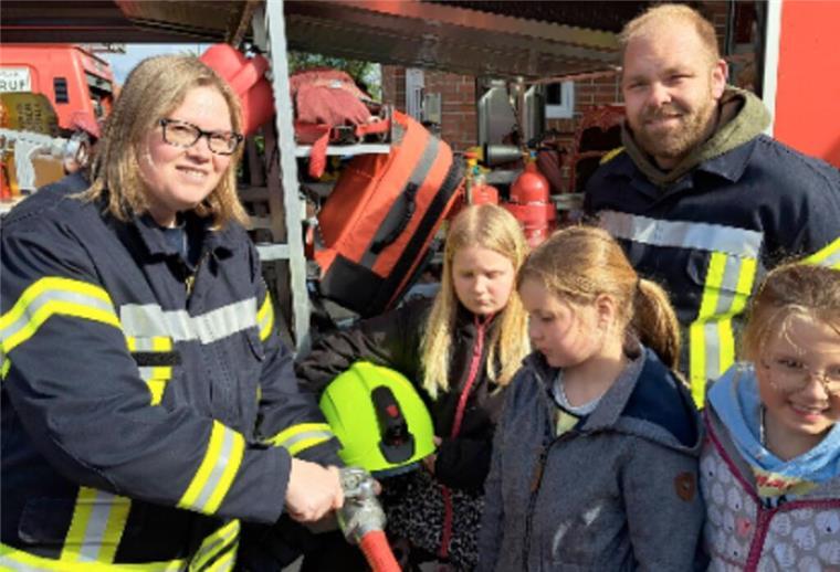 Nachwuchs für Einsatzkräfte: Erste Kinderfeuerwehr in Hagen Kinderfeuerwehrwartin Tina Bock-Horning und ihr Stellvertreter Sören Marten zeigen den Kindern die Ausrüstung der Feuerwehr.