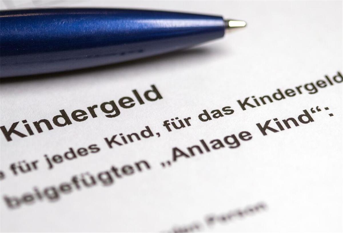  Ein Kugelschreiber liegt auf einem teilweise ausgefüllten Antrag auf Kindergeld. 