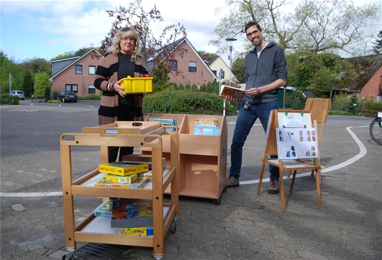 Kita to go: Bücher und Spiele stehen auch in Drangstedt zum Abholen bereit. Iris Dittmann, zuständige Fachbereichsleiterin bei der Stadt Geestland, und Kitaleiter Daniel Altenbeck freuen sich auf die jungen Nutzer. Foto Schoener