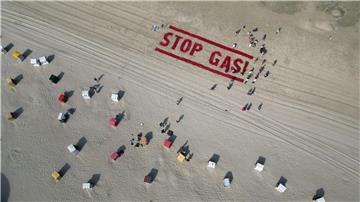 Klimaschutzaktivisten von Fridays for Future schreiben ihre Forderung nach einem Ende der Gasförderung auf den Strand der Insel Borkum. 