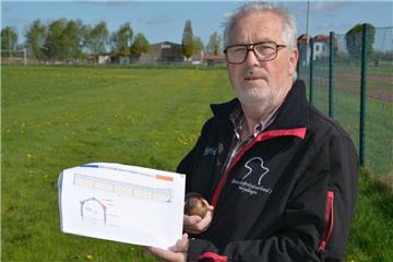 Klootschießerkreis-Vorsitzender Siegfried Hodel zeigt auf dem Sportplatz 2 in Stollhamm die Pläne für das Klootschießer-Leistungszentrum. Hinten ist die Reithalle am Burgweg zu sehen. Wenn alles klappt, könnte der Kloot dort ab Anfang oder Mitte 2019 fliegen.