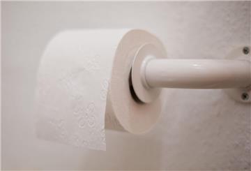 Eine Rolle Toilettenpapier hängt an einem Halter.