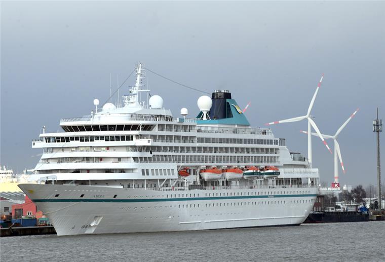Kreuzfahrten ab Bremerhaven: Das sind die Phoenix-Pläne Ein Kreuzfahrtschiff liegt in einem Hafen. Dahinter sind Windkrafträder zu sehen.