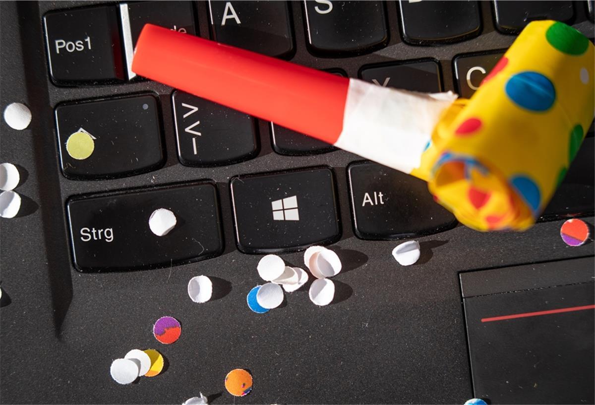 Konfetti und eine Tröte liegen auf einem Notebook. Aufgrund von Corona fällt der klassische Straßenkarneval und die Karnevalssitzungen aus in diesem Jahr.