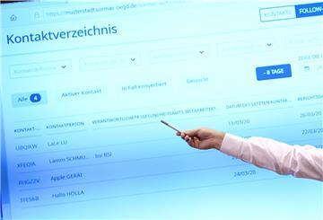 Person mit Stift in der Hand zeigt auf eine Leinwand. 