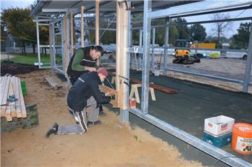 Konzentrierte Millimeterarbeit: Björn Tietje (vorne) und Günter Grell montieren die Holzlatten für die Außenhaut der neuen Rad- und Busstation in Bad Bederkesa.
