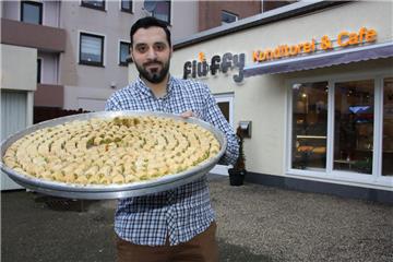 Kostprobe gefällig? Adeb Al Kurdi aus Syrien präsentiert ein Tablett mit kleinen Leckereien. In der Grashoffstraße hat er im Oktober eine Konditorei mit Café eröffnet. Das Geschäft trägt den Namen Fluffy.  