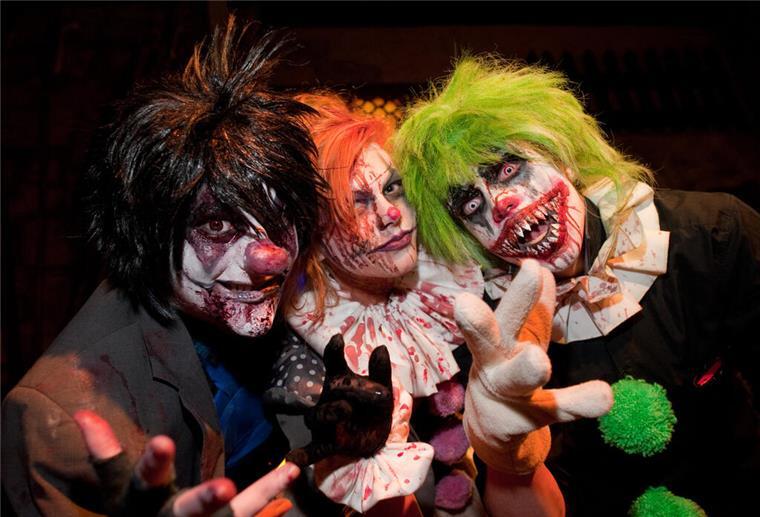Drei Personen haben sich zu Halloween schaurige Kostürme angezogen.