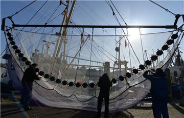 Krabbenfischer arbeiten im Hafen am Netz ihres Kutters.