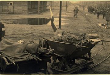 Kranke KZ-Häftlinge auf Wagen der Lorenbahn des Stalag X B Sandbostel.