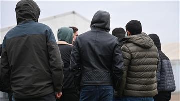 Kriegsflüchtlinge stehen auf dem Gelände einer Flüchtlingsunterkunft zusammen.