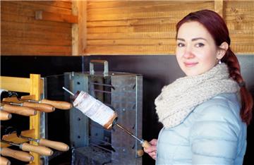 Kristina Förster in ihrem mobilen Verkaufsstand vor dem Baumstriezel-Ofen.