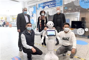 Künstliche Intelligenz in der Oberen Bürger: Der Roboter Pepper wird von den beiden Bremerhavener Studenten Sahin Gültekin (links) und Yuvakvechheka Som auf einen Einsatz in der Tourismus-Werbung vorbereitet. Im Hintergrund freuen sich darüber (von links): Oberbürgermeister Melf Grantz, die KI-Expertin Professorin Dr. Nadija Petram und Dr. Rolf Meyer, Chef der Tourismusgesellschaft Erlebnis Bremerhaven.