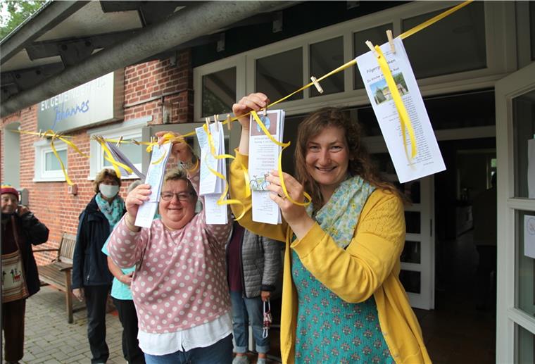 Küsterin Silvia Pauper und Pastorin Lara Schilde haben die Pilgerpässe vor dem Gemeindehaus in Bexhövede an einer Wäscheleine befestigt.