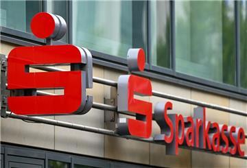 Das Logo der Sparkasse ist  über dem Eingang einer Sparkassenfiliale zu sehen.